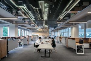 Largely empty workplace with a few workers wearing masks